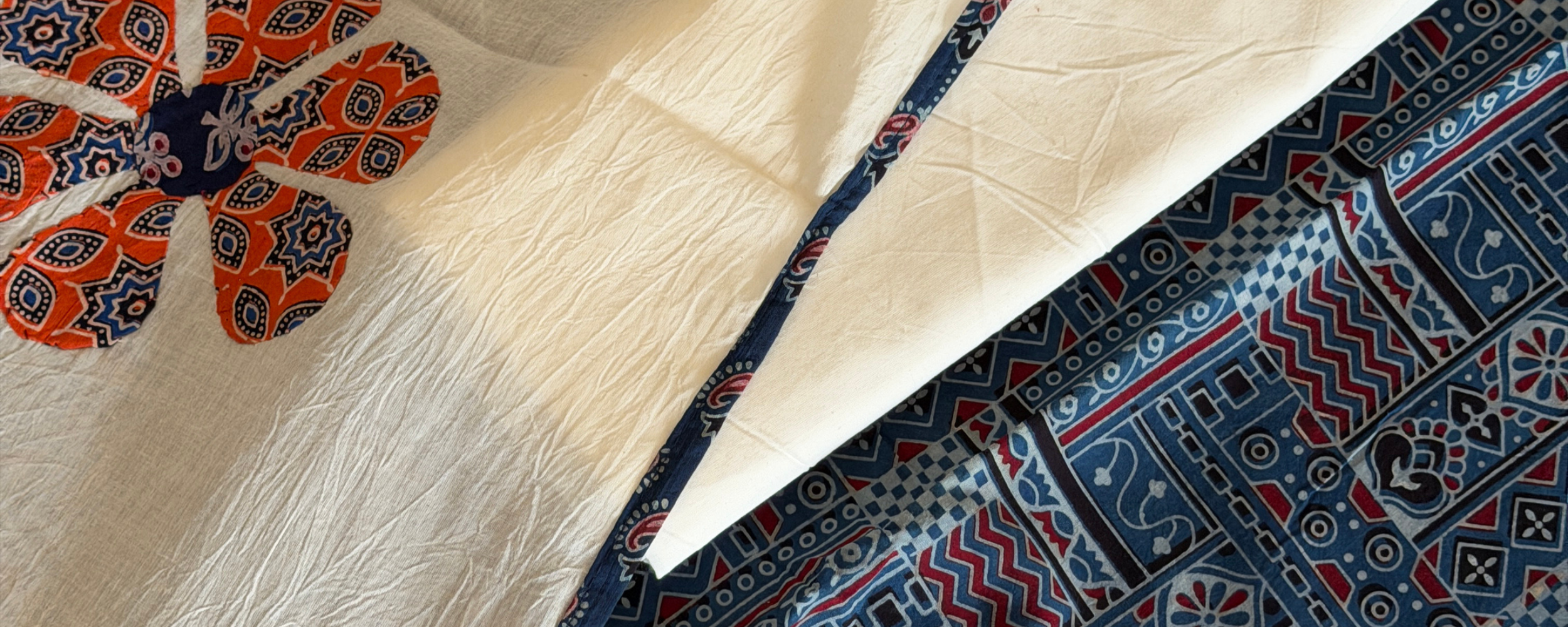 Ajrakh hand block printed women's suit with a traditional printed dupatta and coordinated fabric displayed in a flat lay